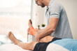 © AK Coop/peopleimages.com - Foot pain, physiotherapy and man with patient for wellness, medical service and consulting. Healthcare, chiropractor and physical therapist with person for rehabilitation, recovery and anatomy