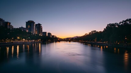 Poster - Serene Cityscape at Dusk with Glowing Lights and Calm River Reflection