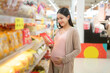 © tonefotografia - Beautiful pregnant woman shopping bakery and bread at grocery shop