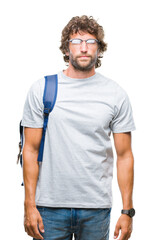 Poster - Handsome hispanic student man wearing backpack and glasses over isolated background with serious expression on face. Simple and natural looking at the camera.