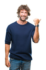 Poster - Handsome hispanic model man wearing winter sweater over isolated background smiling with happy face looking and pointing to the side with thumb up.