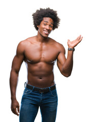 Wall Mural - Afro american shirtless man showing nude body over isolated background smiling cheerful presenting and pointing with palm of hand looking at the camera.