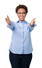 Sticker - Young beautiful african american business woman over isolated background looking at the camera smiling with open arms for hug. Cheerful expression embracing happiness.