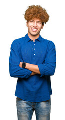 Wall Mural - Young handsome elegant man with afro hair happy face smiling with crossed arms looking at the camera. Positive person.