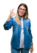 © Krakenimages.com - Young beautiful woman over wearing glasses over isolated background smiling positive doing ok sign with hand and fingers. Successful expression.