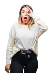 Wall Mural - Young beautiful woman casual white sweater over isolated background doing ok gesture shocked with surprised face, eye looking through fingers. Unbelieving expression.