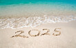 © Sergey - Top view of 2025 numbers written on the sand of coastline with frothy waves. 2025 new year concept.
