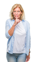 Sticker - Middle age blonde woman over isolated background asking to be quiet with finger on lips. Silence and secret concept.