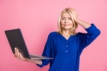 Wall Mural - Photo portrait of pretty senior female hold netbook stressed wear trendy blue outfit isolated on pink color background