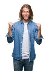 Canvas Print - Young handsome man with long hair over isolated background celebrating surprised and amazed for success with arms raised and open eyes. Winner concept.