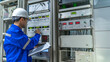 © reewungjunerr - Electrical engineer woman checking voltage at the Power Distribution Cabinet in the control room,preventive maintenance Yearly,Thailand Electrician working at company