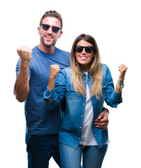 Poster - Young couple in love wearing sunglasses over isolated background celebrating surprised and amazed for success with arms raised and open eyes. Winner concept.