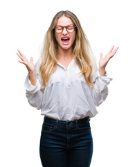 Wall Mural - Young beautiful blonde business woman wearing glasses over isolated background celebrating mad and crazy for success with arms raised and closed eyes screaming excited. Winner concept