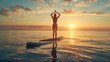 © fivan - A woman practicing yoga on a paddleboard during a peaceful sunrise session