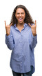 © Krakenimages.com - Young hispanic business woman shouting with crazy expression doing rock symbol with hands up. Music star. Heavy concept.