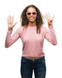© Krakenimages.com - Beautiful young hispanic woman wearing sunglasses showing and pointing up with fingers number nine while smiling confident and happy.