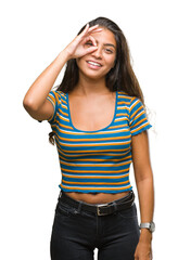 Poster - Young beautiful arab woman over isolated background doing ok gesture with hand smiling, eye looking through fingers with happy face.