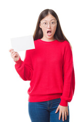 Wall Mural - Young Chinese woman over isolated background holding blank card scared in shock with a surprise face, afraid and excited with fear expression