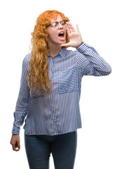 Sticker - Young redhead bussines woman shouting and screaming loud to side with hand on mouth. Communication concept.