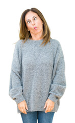 Wall Mural - Beautiful middle age woman wearing winter sweater over isolated background making fish face with lips, crazy and comical gesture. Funny expression.