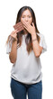 © Krakenimages.com - Young asian woman eating chocolate bar over isolated background cover mouth with hand shocked with shame for mistake, expression of fear, scared in silence, secret concept