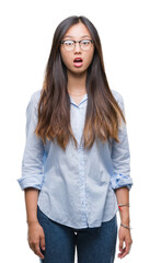 Poster - Young asian business woman wearing glasses over isolated background afraid and shocked with surprise expression, fear and excited face.