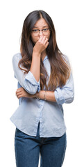 Canvas Print - Young asian business woman wearing glasses over isolated background smelling something stinky and disgusting, intolerable smell, holding breath with fingers on nose. Bad smells concept.