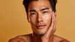 © StasySin - A man with a skincare product on his face poses against a warm background