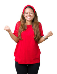 Sticker - Young beautiful brunette woman wearing red t-shirt over isolated background celebrating surprised and amazed for success with arms raised and open eyes. Winner concept.