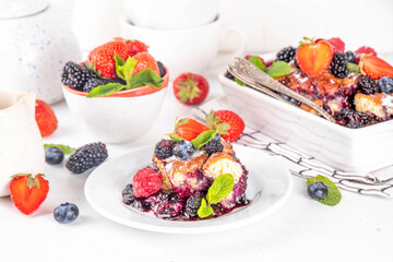 Wall Mural - Homemade sweet berry cobbler pie cake with various garden forest berries - strawberry, blackberry, blueberry, healthy summer dessert recipe in baking pan and plate, copy space