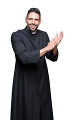 Canvas Print - Young Christian priest over isolated background Clapping and applauding happy and joyful, smiling proud hands together