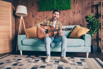 Poster - Photo of attractive funny guy wear plaid shirt smiling enjoying weekend playing guitar indoors room home house