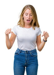 Wall Mural - Beautiful young woman wearing casual white t-shirt over isolated background Pointing down with fingers showing advertisement, surprised face and open mouth