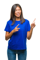 Poster - Young asian woman over isolated background smiling and looking at the camera pointing with two hands and fingers to the side.