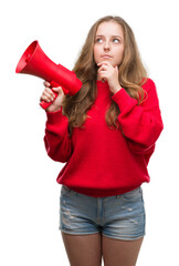 Sticker - Young blonde woman holding red megaphone serious face thinking about question, very confused idea