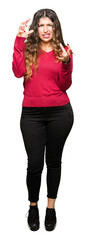 Sticker - Young beautiful woman wearing red sweater Shouting frustrated with rage, hands trying to strangle, yelling mad