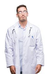 Canvas Print - Handsome young doctor man smiling looking side and staring away thinking.