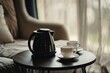 © Maxim Borbut - On a table by a sofa couch in the hotel room is a white tea cup and a coffee cup with a kettle.