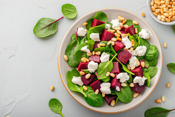 Wall Mural - A salad with beets, spinach, and cheese is served in a white plate