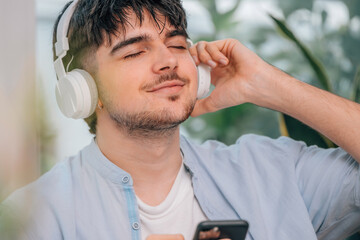 Poster - young man at home with headphones and mobile phone