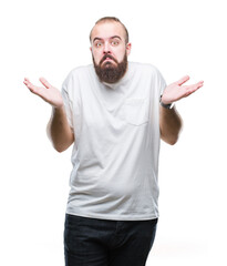 Poster - Young caucasian hipster man wearing casual t-shirt over isolated background clueless and confused expression with arms and hands raised. Doubt concept.