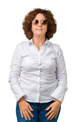 Sticker - Beautiful middle ager senior business woman wearing sunglasses over isolated background with serious expression on face. Simple and natural looking at the camera.