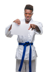 Sticker - Young african american man over isolated background wearing kimono holding paper pointing with finger to the camera and to you, hand sign, positive and confident gesture from the front