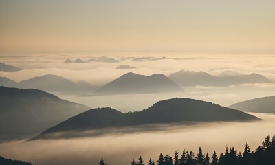 Wall Mural - mountain range enveloped in fog, with peaks just visible through the mist.