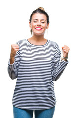 Poster - Young beautiful woman casual stripes sweater over isolated background excited for success with arms raised celebrating victory smiling. Winner concept.