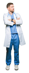 Canvas Print - Handsome doctor man wearing medical uniform over isolated background smiling looking to the side with arms crossed convinced and confident