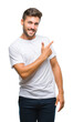 © Krakenimages.com - Young handsome man over isolated background cheerful with a smile of face pointing with hand and finger up to the side with happy and natural expression on face looking at the camera.