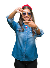 Poster - Young beautiful arab woman wearing sunglasses over isolated background smiling making frame with hands and fingers with happy face. Creativity and photography concept.