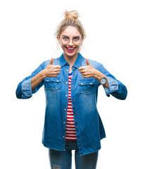 Sticker - Young beautiful blonde woman wearing glasses over isolated background success sign doing positive gesture with hand, thumbs up smiling and happy. Looking at the camera with cheerful expression.