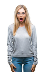 Canvas Print - Young beautiful blonde woman wearing glasses over isolated background afraid and shocked with surprise expression, fear and excited face.